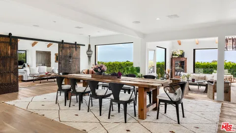 a kitchen with stainless steel appliances granite countertop a stove and chairs with wooden floors