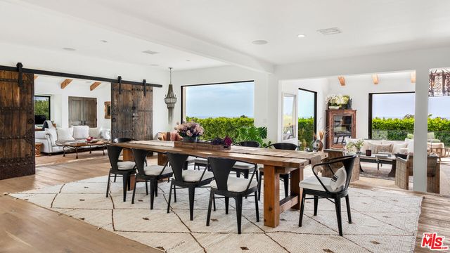 a kitchen with stainless steel appliances granite countertop a stove and chairs with wooden floors