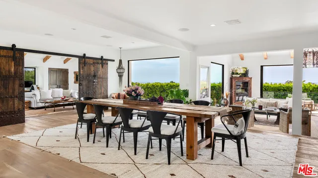 a kitchen with stainless steel appliances granite countertop a stove and chairs with wooden floors