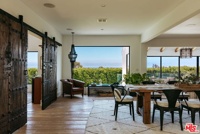 a kitchen with stainless steel appliances kitchen island granite countertop a stove a refrigerator a sink dishwasher and white cabinets with wooden floor