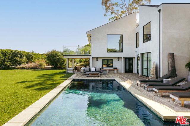 a view of house with swimming pool yard and outdoor seating