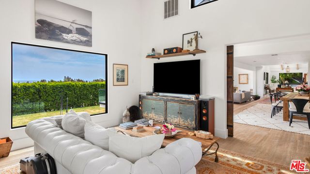 a kitchen with a stove and a flat screen tv