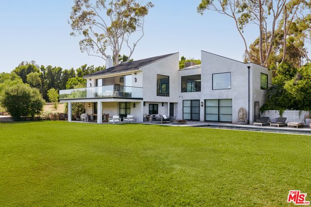 a view of swimming pool with two chairs and a fire pit