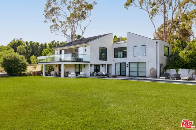a view of swimming pool with two chairs and a fire pit