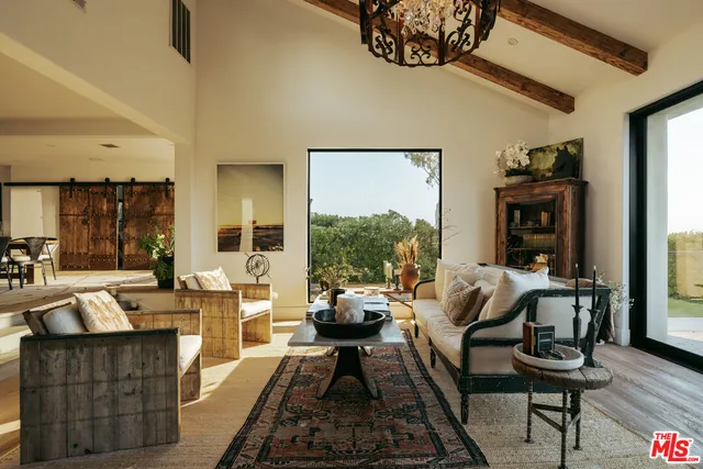 a bedroom with a bed and large windows