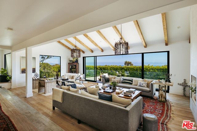 a living room with lots of furniture and a large window