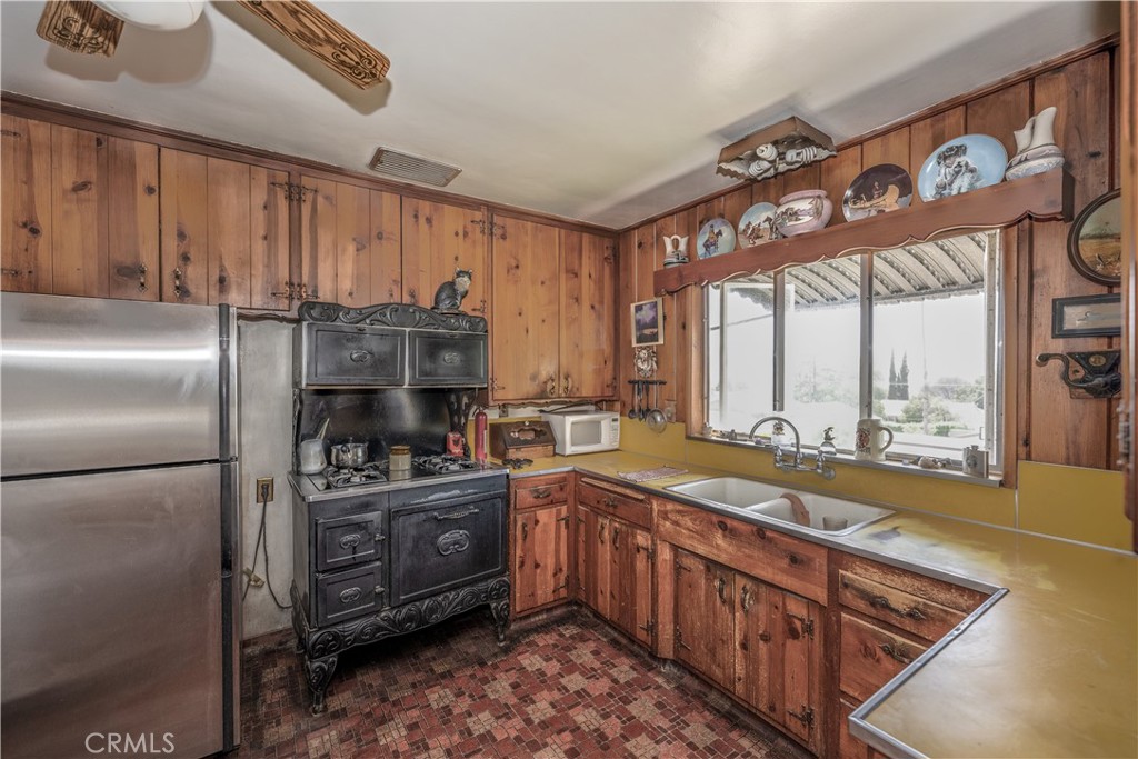 10343 Helendale Avenue Tujunga, CA 91042 - Photo 11 of 30 a kitchen with stainless steel appliances granite countertop a stove a sink and a refrigerator