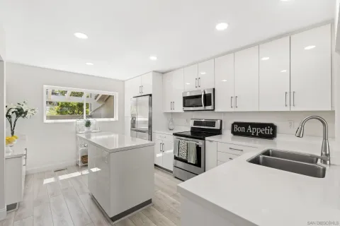 a kitchen with white cabinets appliances and sink