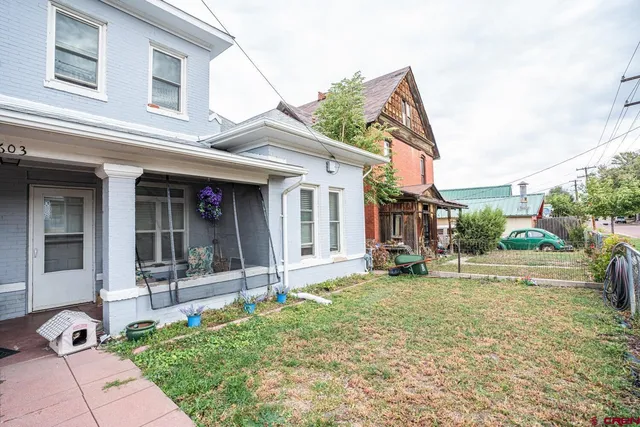 a view of a house with a patio and a yard