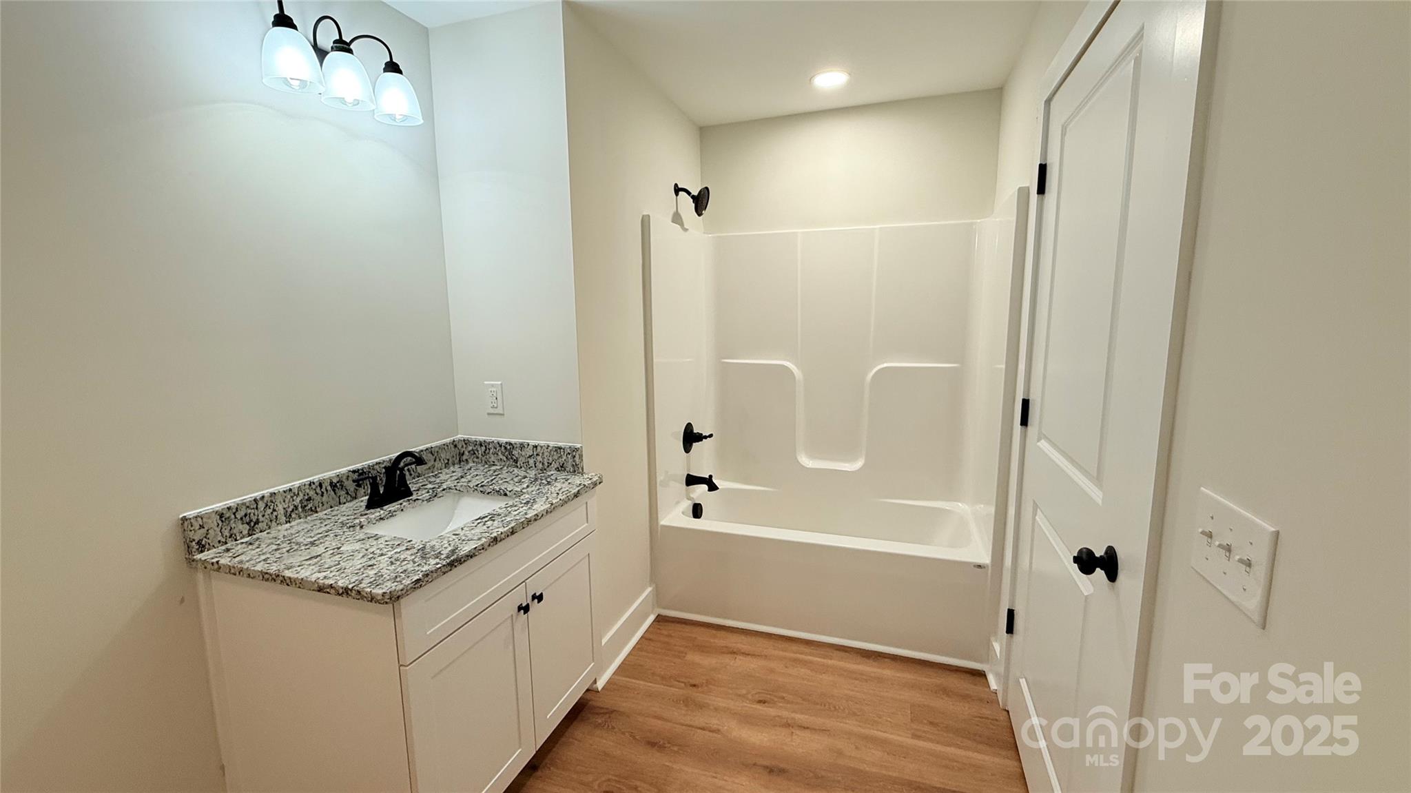 203 Beacon Avenue Morganton, NC 28655 - Photo 16 of 18 a bathroom with a granite countertop sink a toilet and shower