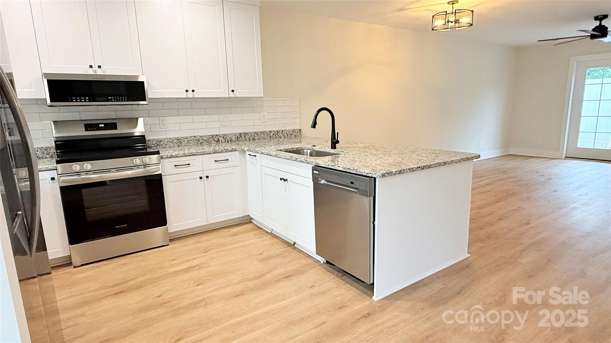 203 Beacon Avenue Morganton, NC 28655 - Photo 2 of 18 a kitchen with stainless steel appliances granite countertop a stove top oven a sink a microwave and a refrigerator