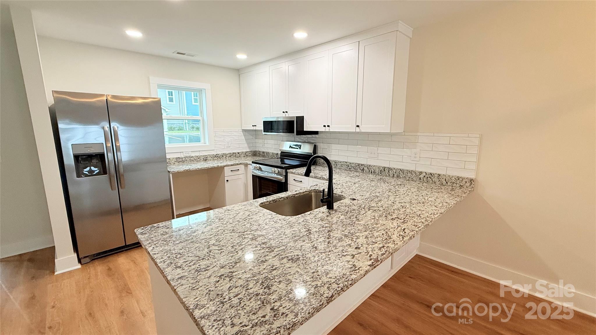 203 Beacon Avenue Morganton, NC 28655 - Photo 4 of 18 a kitchen with stainless steel appliances granite countertop a sink stove and refrigerator
