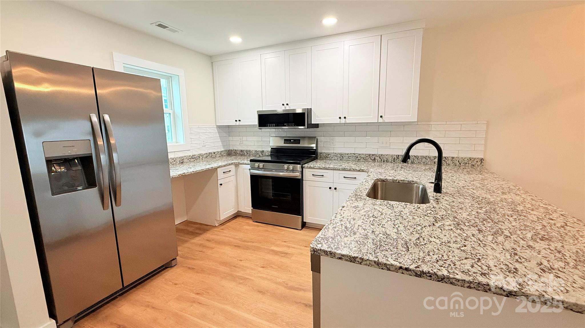 203 Beacon Avenue Morganton, NC 28655 - Photo 5 of 18 a kitchen with stainless steel appliances granite countertop a sink a stove and a refrigerator