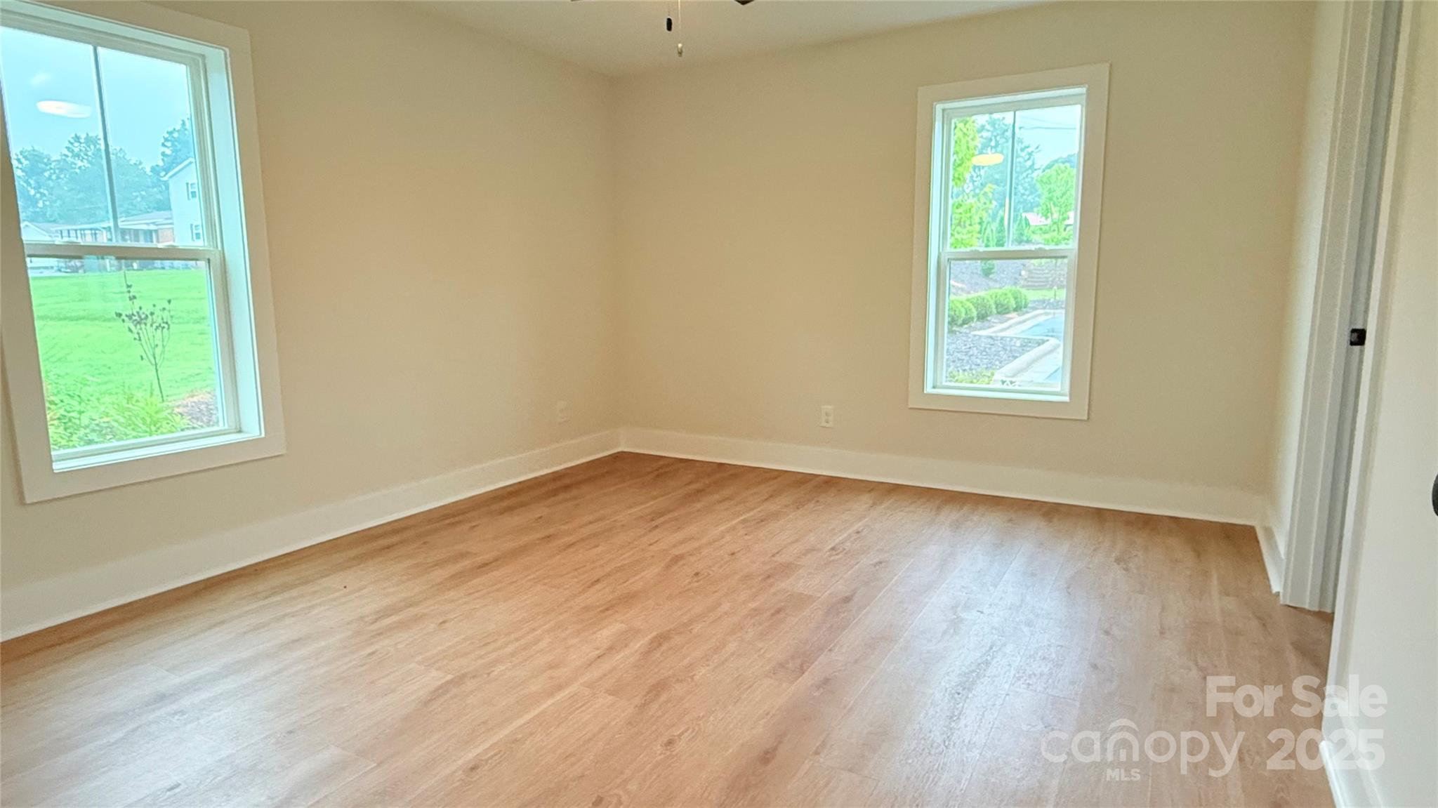 203 Beacon Avenue Morganton, NC 28655 - Photo 10 of 18 an empty room with wooden floor and windows