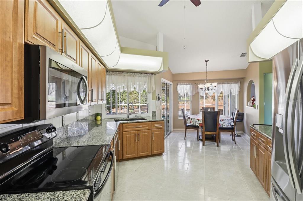 3 Ipomoea Court Homosassa, FL 34446 - Photo 12 of 46 a kitchen with stainless steel appliances granite countertop a stove and a view of living room