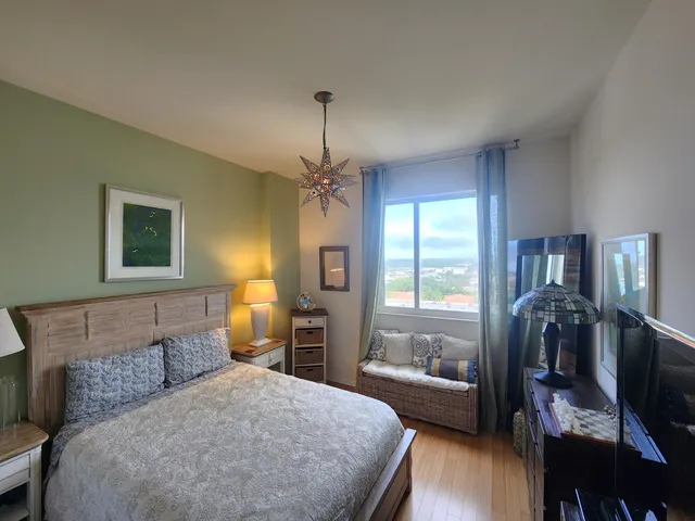 a bedroom with a bed a table and flat screen tv