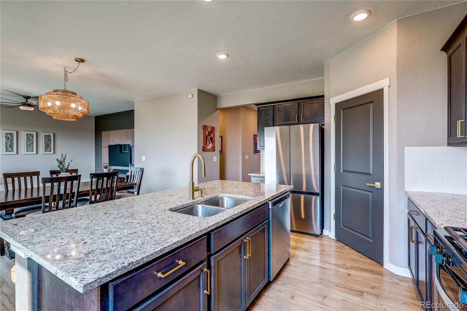 1335 Copeland Falls Road Severance, CO 80550 - Photo 11 of 48 a kitchen with stainless steel appliances granite countertop a kitchen island a stove and a refrigerator