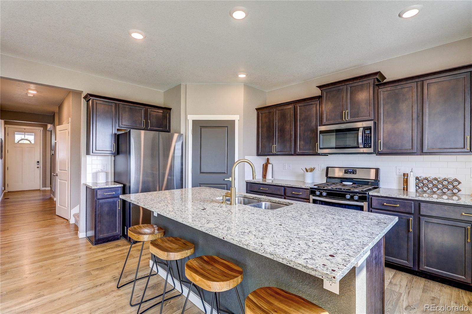1335 Copeland Falls Road Severance, CO 80550 - Photo 3 of 48 a kitchen with stainless steel appliances granite countertop a sink refrigerator and microwave
