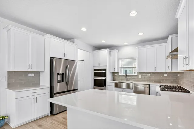 a kitchen with stainless steel appliances a refrigerator sink and microwave