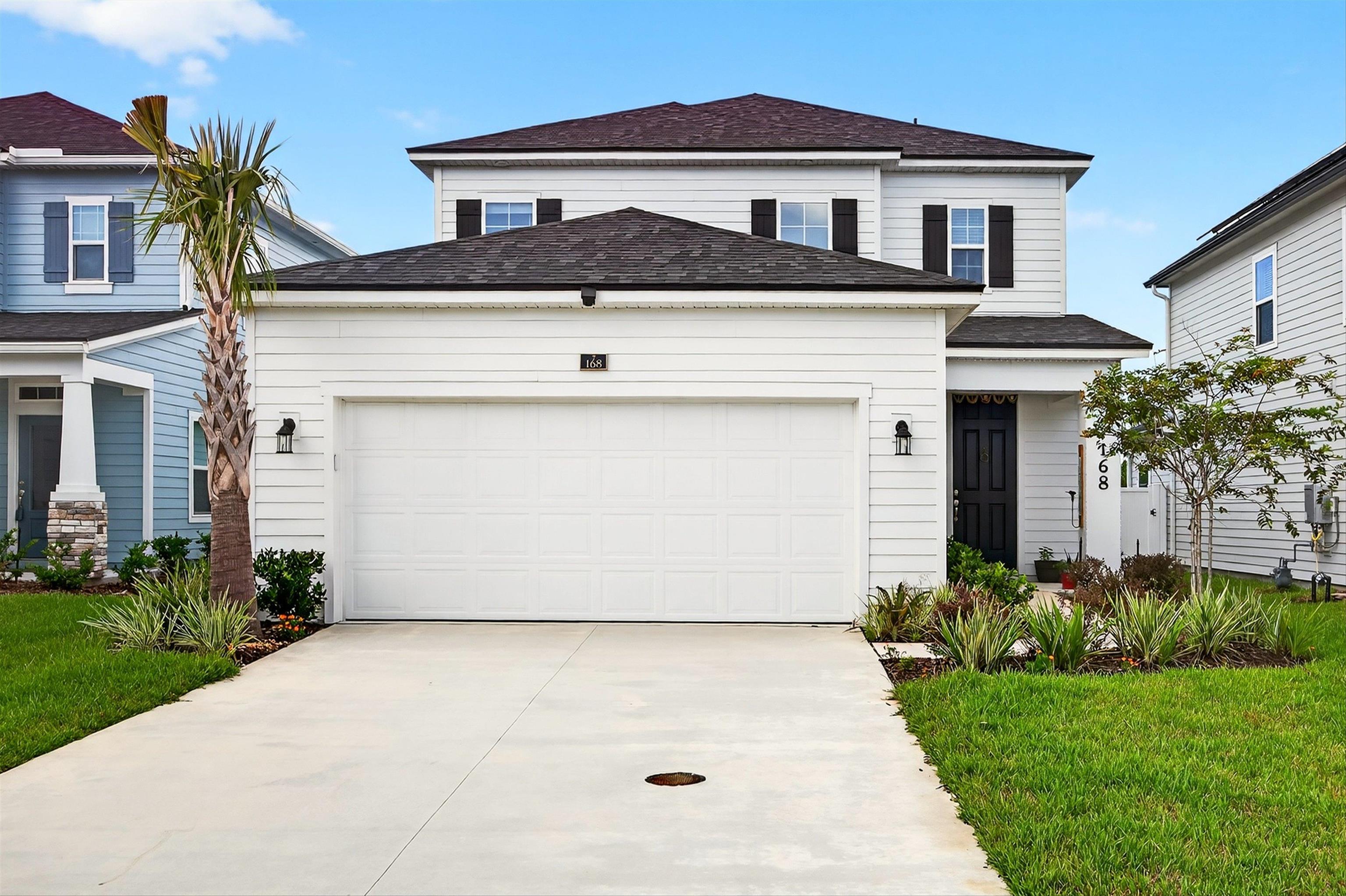 168 Torres Trace St. Augustine, FL 32095 - Photo 2 of 50 a front view of a house with a yard and garage