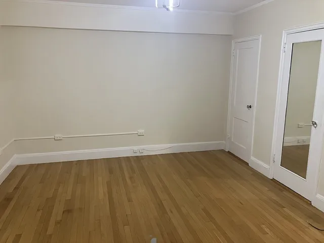 a view of a room with wooden floor