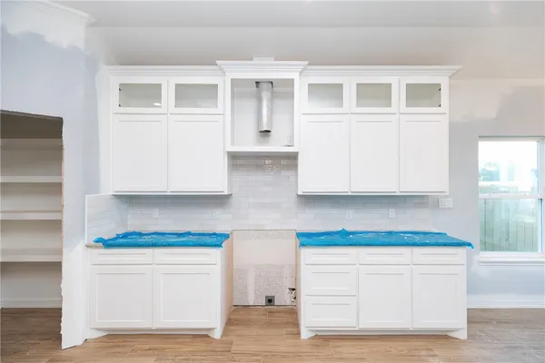 a kitchen with white cabinets and a stove