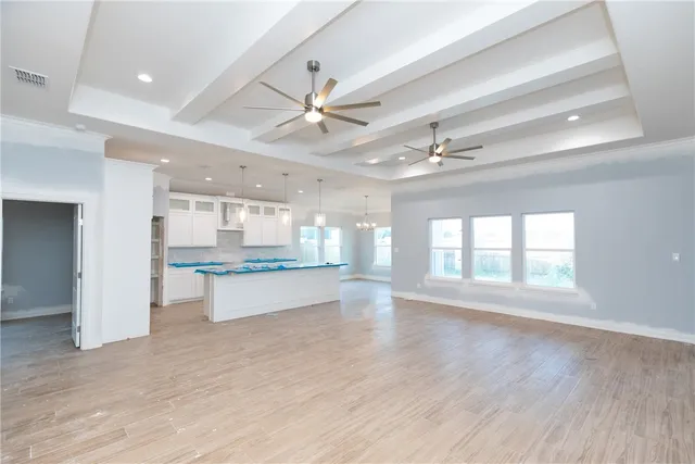 a large kitchen with a large counter top a sink stainless steel appliances and cabinets