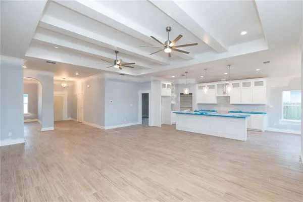 a view of an empty room and kitchen view