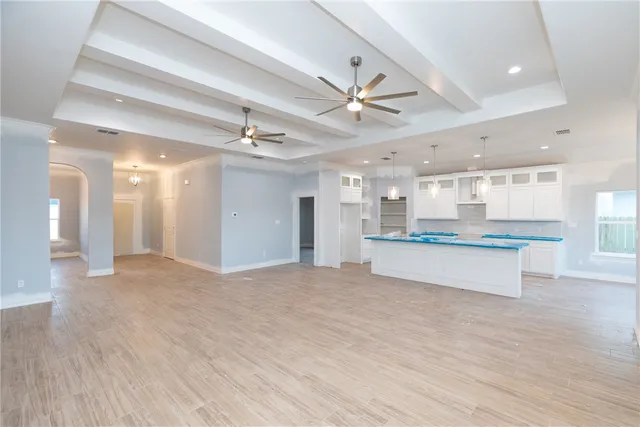 a view of an empty room and kitchen view