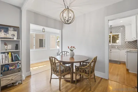 a view of a dining room with furniture a book and wooden floor