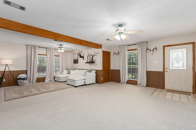 a living room with furniture and a ceiling fan