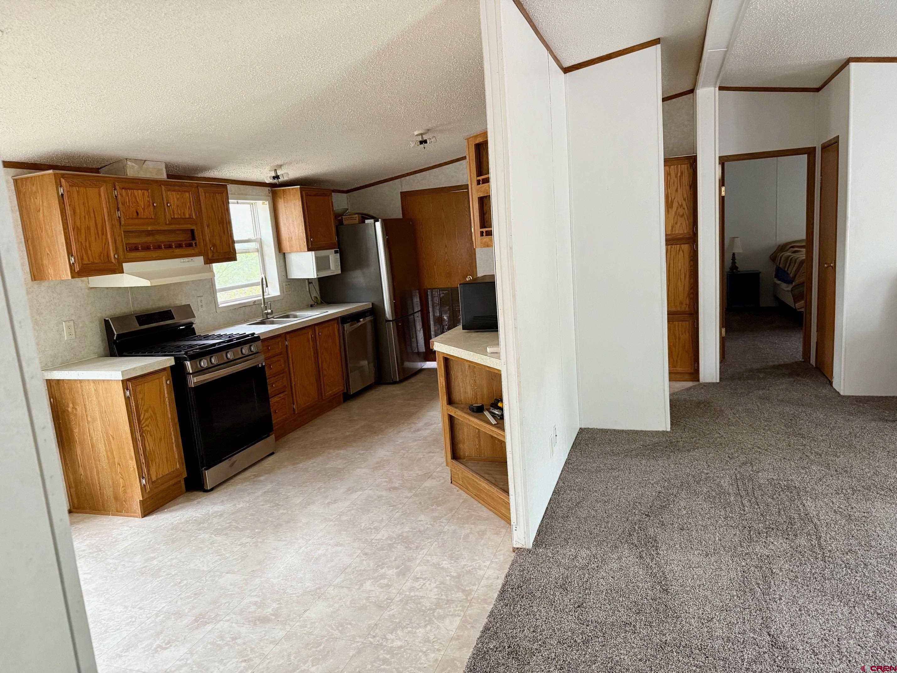 440 Park Drive Naturita, CO 81422 - Photo 11 of 18 a view of a kitchen with fridge and wooden floor