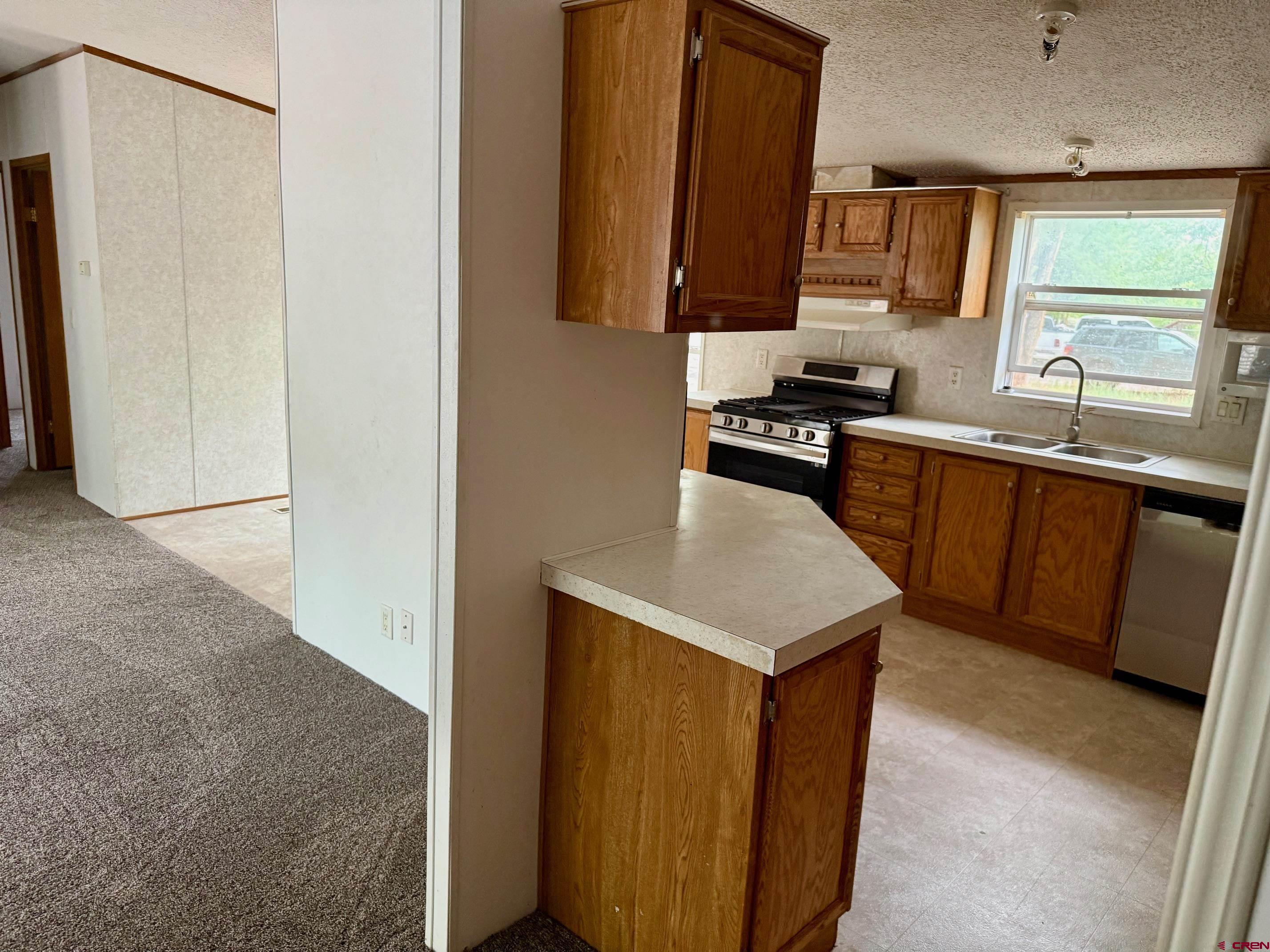 440 Park Drive Naturita, CO 81422 - Photo 12 of 18 a kitchen with stainless steel appliances granite countertop a sink stove and refrigerator