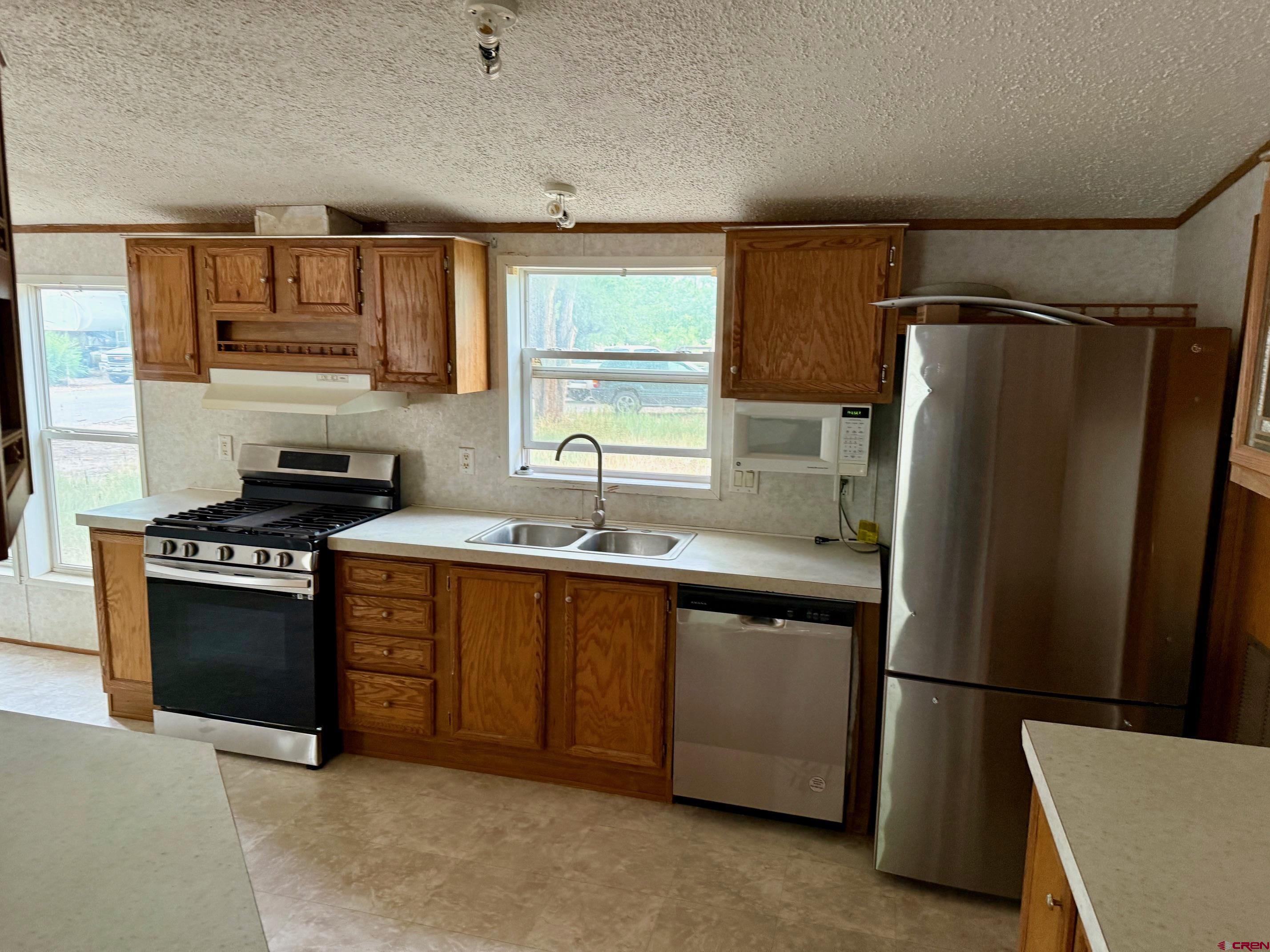 440 Park Drive Naturita, CO 81422 - Photo 9 of 18 a kitchen with stainless steel appliances granite countertop a refrigerator and a sink
