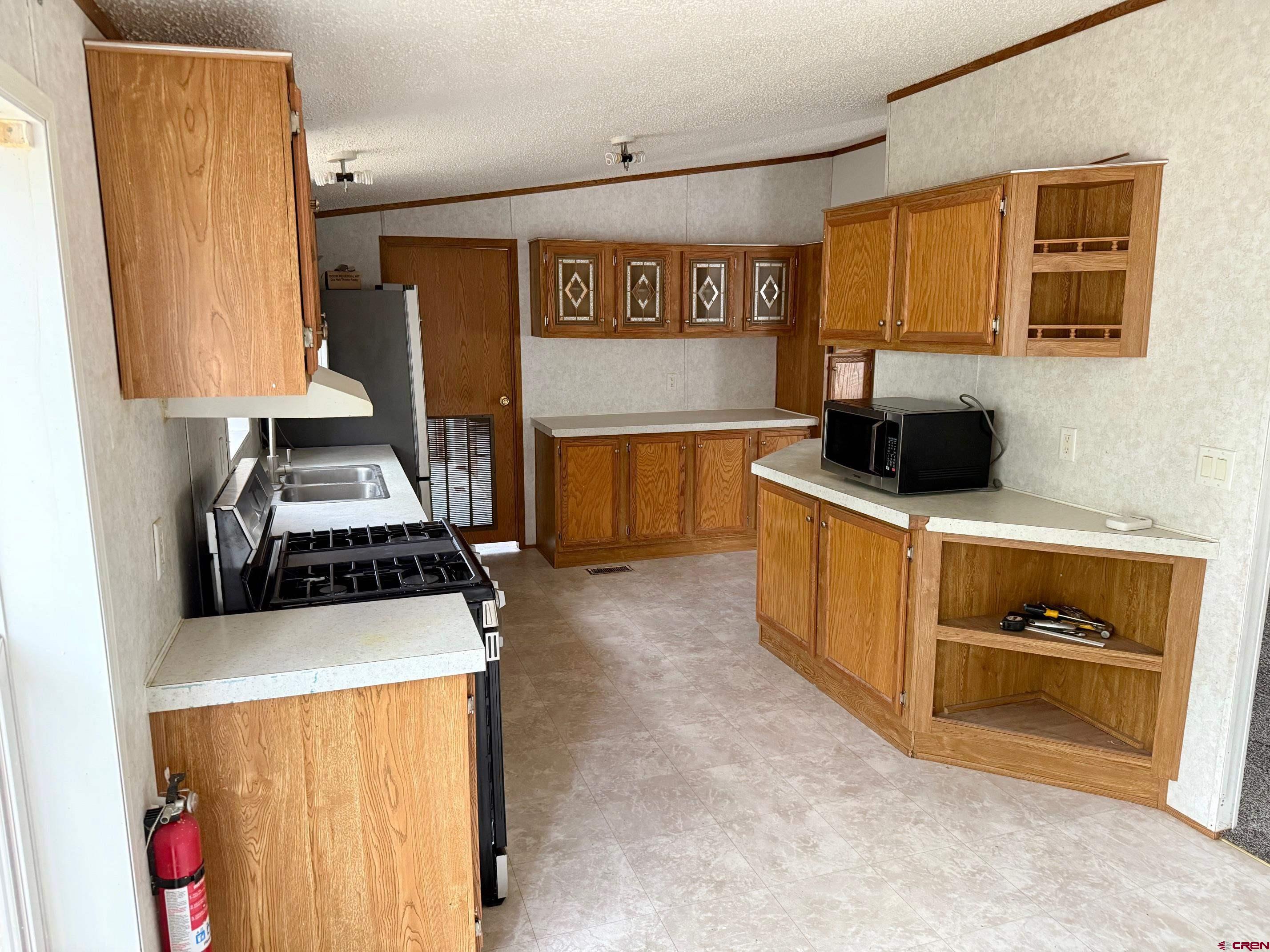 440 Park Drive Naturita, CO 81422 - Photo 10 of 18 a kitchen with stainless steel appliances a stove a microwave and a refrigerator
