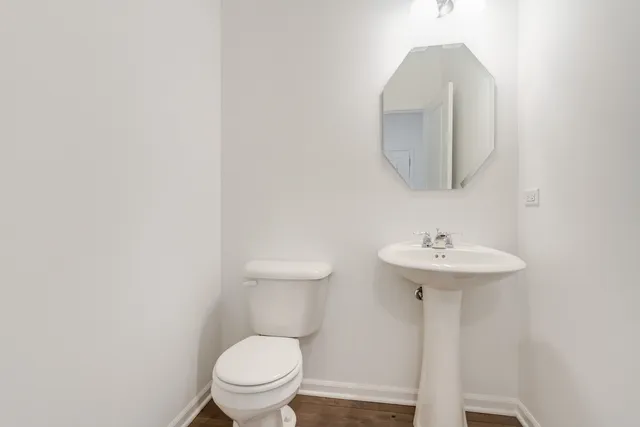 a bathroom with a toilet a sink and mirror