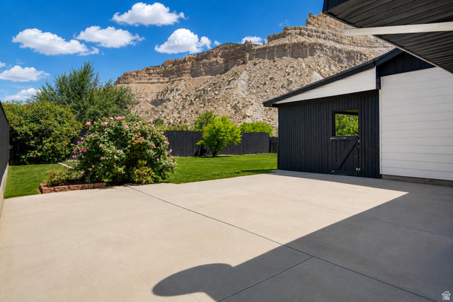 100 Third North Helper, UT 84526 - Photo 4 of 30 Exterior concrete patio area bordered by a manicured lawn and mature shrubs
