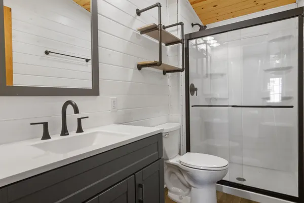a bathroom with a sink a toilet and shower