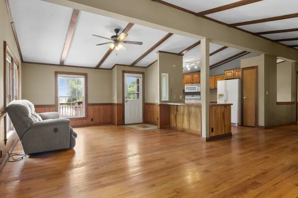 a view of a livingroom with furniture wooden floor fan and windows