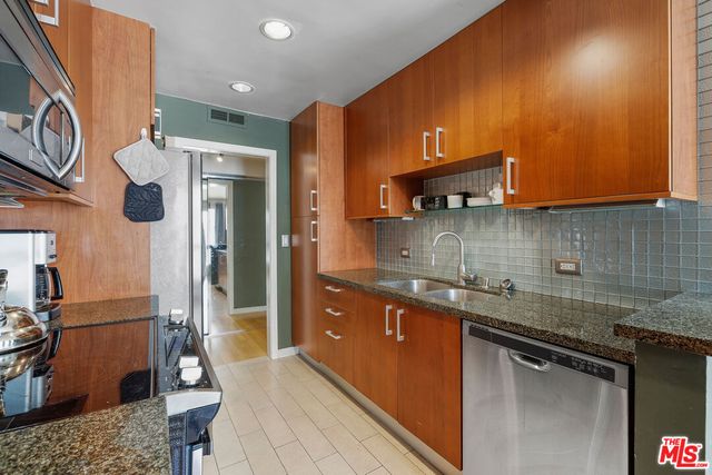 a kitchen with stainless steel appliances granite countertop a sink a stove and a refrigerator