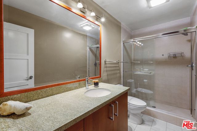 a bathroom with a granite countertop sink toilet and shower