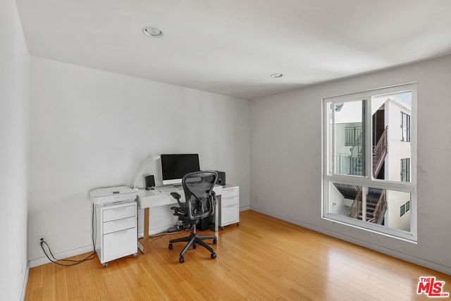 a view of a workspace with furniture and a window