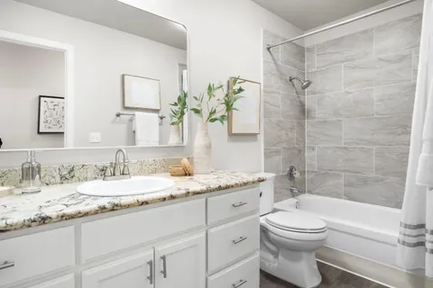 a bathroom with a granite countertop toilet sink and a mirror