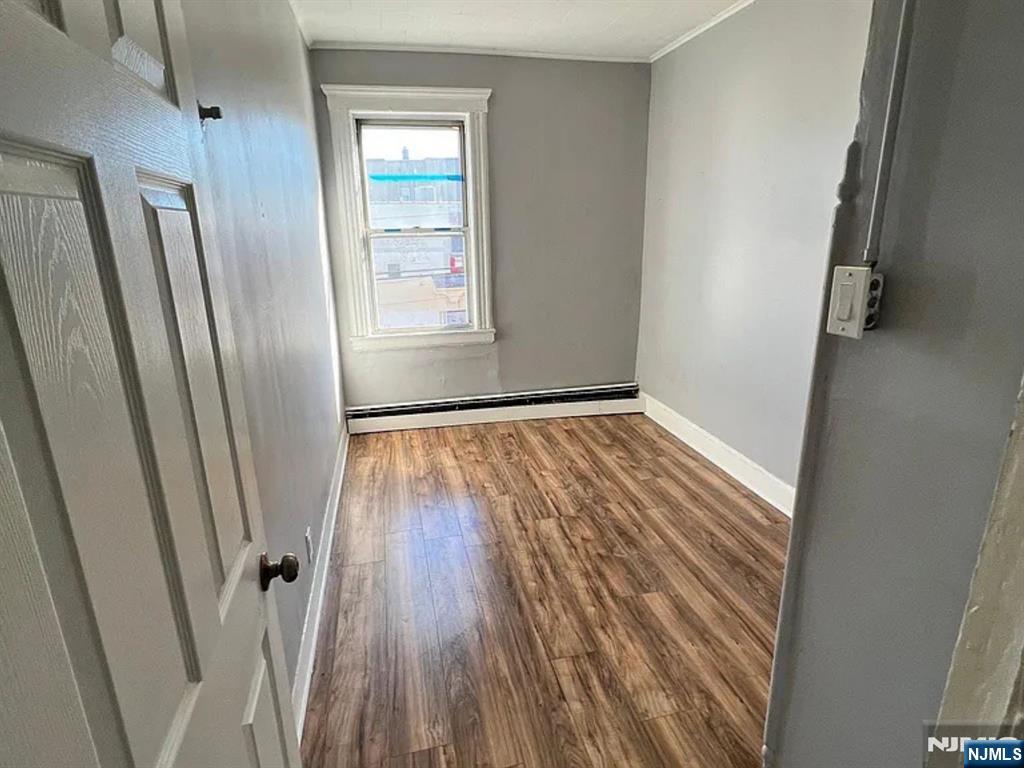 489 Market Street, Unit 2 Paterson, NJ 07501 - Photo 4 of 6 a view of an empty room with wooden floor and a window