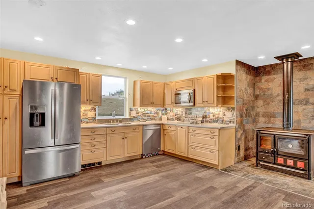 a kitchen with stainless steel appliances granite countertop a refrigerator a stove and a refrigerator