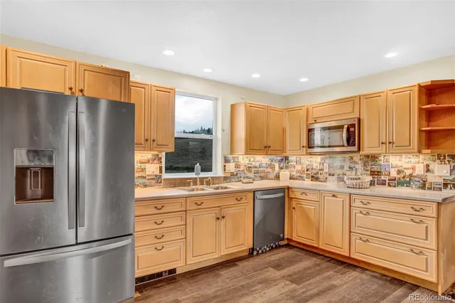 a kitchen with stainless steel appliances granite countertop a refrigerator a stove and a sink