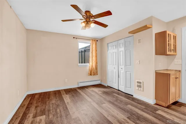 a view of an empty room with window and wooden floor