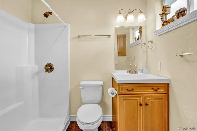 a bathroom with a toilet sink vanity and mirror