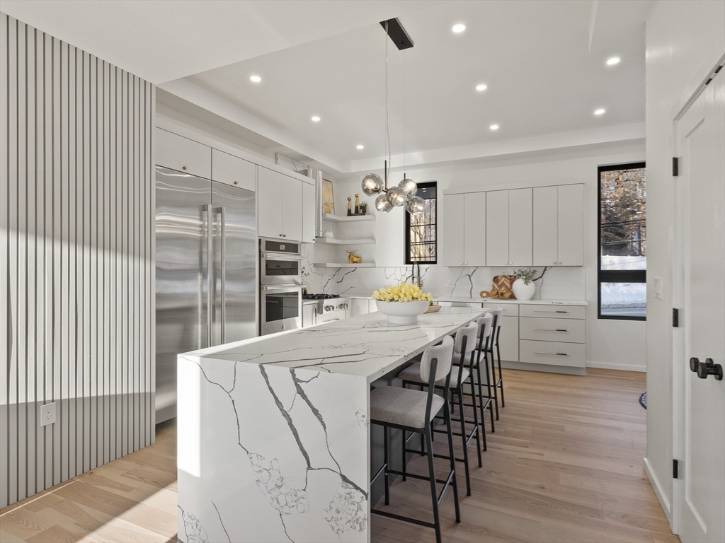 225 Walnut Street Saugus, MA 01906 - Photo 12 of 42 a kitchen with stainless steel appliances kitchen island granite countertop a table chairs sink and cabinets