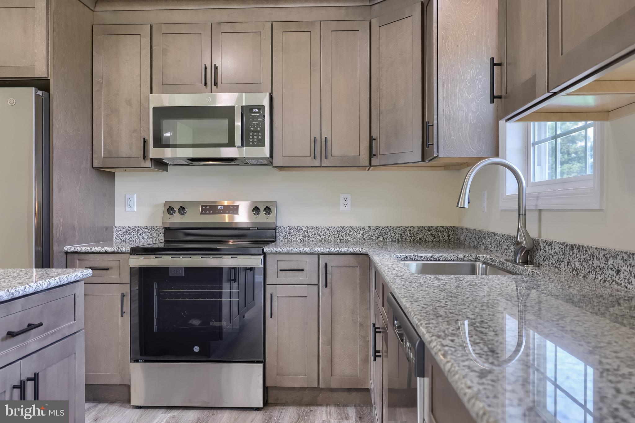6030 Deborah Drive Spring Grove, PA 17362 - Photo 12 of 34 a kitchen with stainless steel appliances granite countertop a stove a sink and a microwave